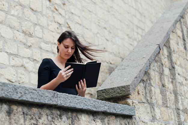 Mädchen, das ein Buch an einem windigen Tag liest