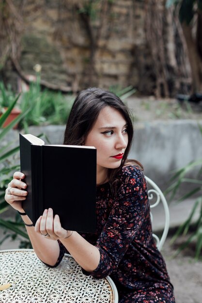 Mädchen, das ein Buch in einer Cafeteria liest