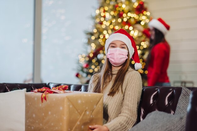 Mädchen, das ein Weihnachtsgeschenk in Weihnachten hält.