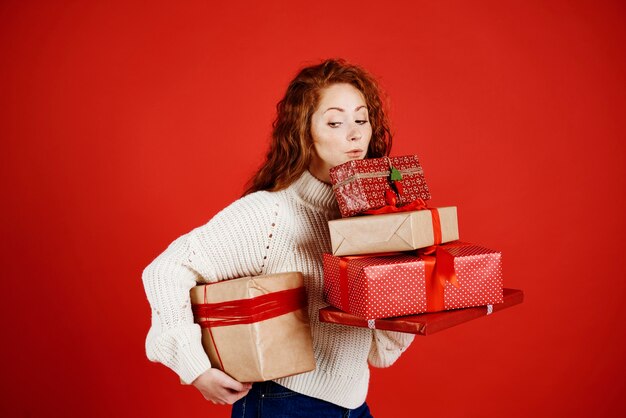 Mädchen, das einen Stapel Weihnachtsgeschenke trägt