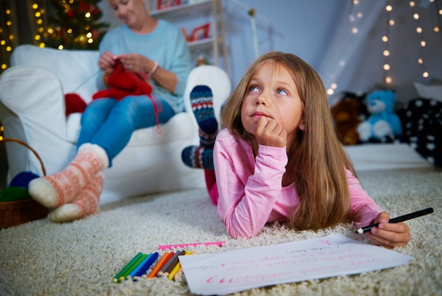 Mädchen, das einen Weihnachtsbrief zum Weihnachtsmann schreibt