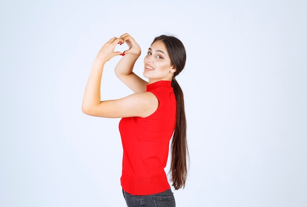 Mädchen, das Herzzeichen in der Hand macht und Liebe sendet.