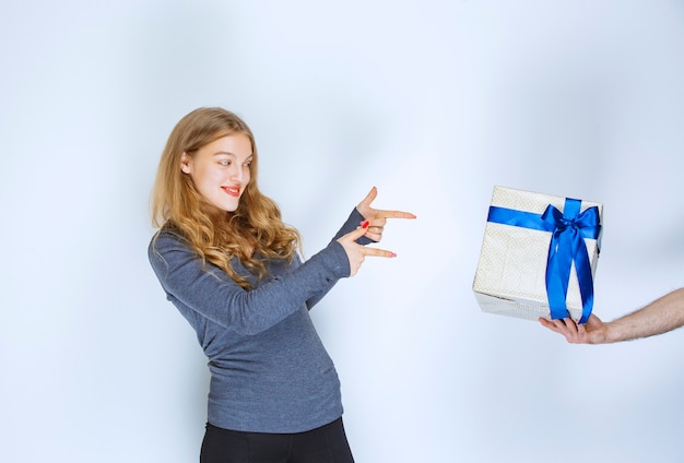 Mädchen, das ihr eine weiße blaue Geschenkbox zeigt, bot ihr an.