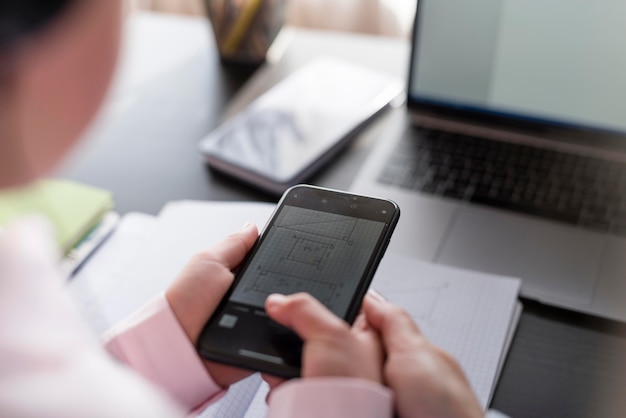 Mädchen, das ihr Telefon benutzt, um ihre Hausaufgaben zu machen