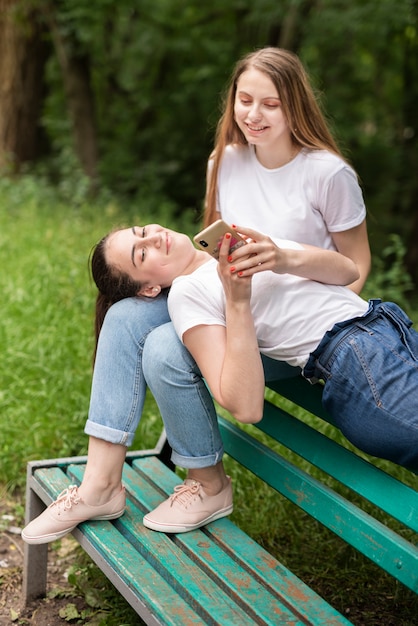 Mädchen, das ihrem Freund etwas am Telefon zeigt