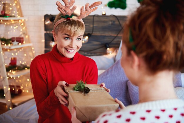 Mädchen, das ihrem Freund Weihnachtsgeschenk gibt