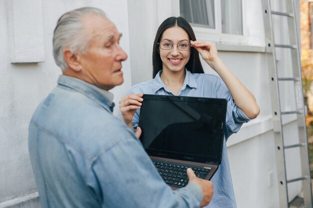 Mädchen, das ihrem Großvater beibringt, wie man einen Laptop benutzt