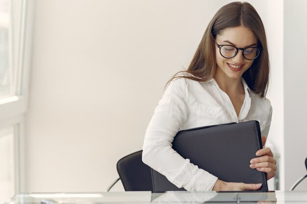 Mädchen, das im Büro mit einem Laptop sitzt