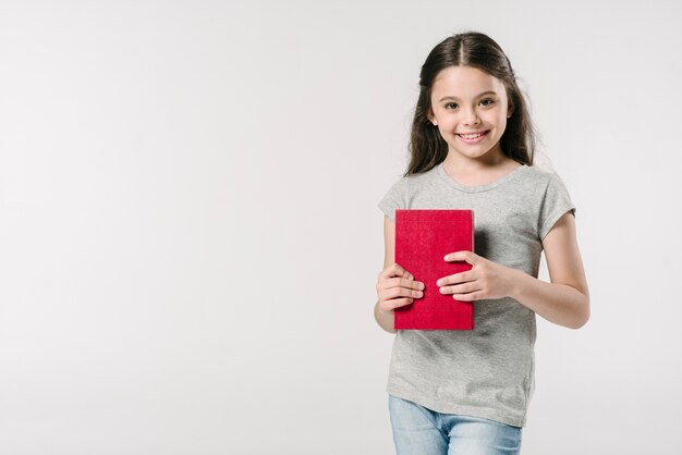 Mädchen, das im Studio mit Buch steht