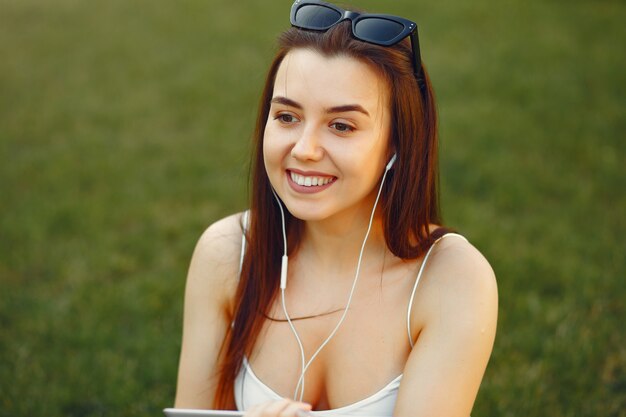 Mädchen, das in einem Universitätscampus unter Verwendung einer Tablette sitzt