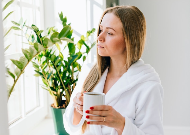 Mädchen, das Kaffee am Badezimmer trinkt