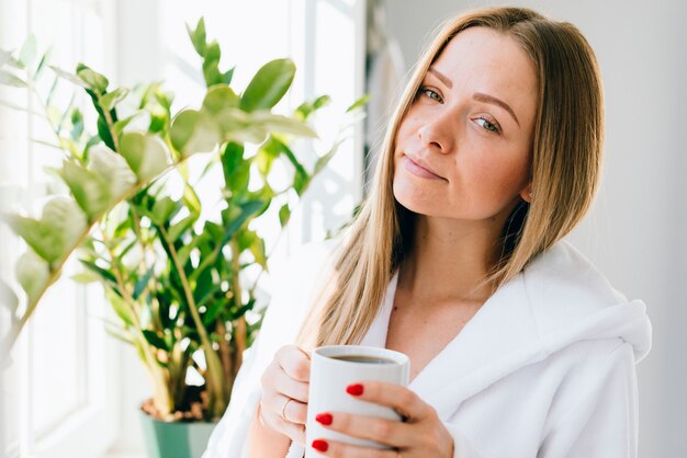 Mädchen, das Kaffee am Badezimmer trinkt