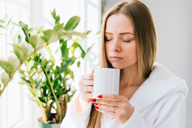 Mädchen, das Kaffee am Badezimmer trinkt