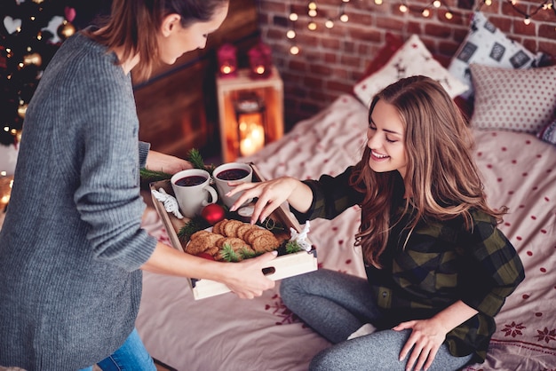 Mädchen, das Kekse und Glühwein mit ihrem Freund teilt