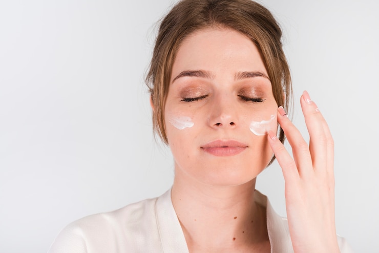 Kostenlose Foto mädchen, das kosmetisches produkt sich aufträgt
