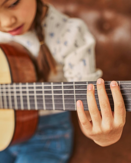 Mädchen, das lernt, wie man zu Hause Gitarre spielt