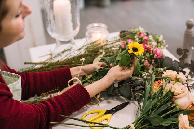 Mädchen, das mit den frischen Blumen machen Blumenstrauß arbeitet