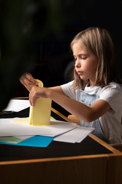 Mädchen, das mit Papier mittlerer Aufnahme kreativ ist