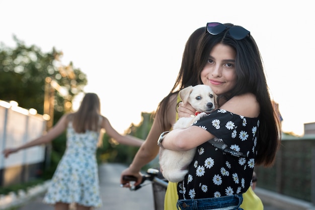 Kostenloses Foto mädchen, das netten hund umarmt und eine kamera betrachtet