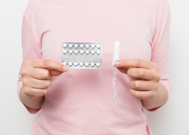 Mädchen, das Pillenblase und -tampon hält