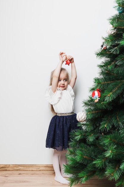 Mädchen, das Weihnachtsbaum verziert