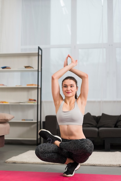 Mädchen, das Yoga in ihrem Haus bildet