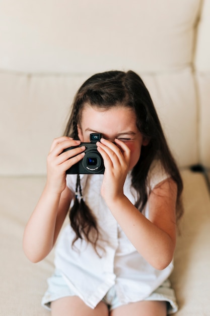 Kostenloses Foto mädchen des hohen winkels, das fotos mit kamera macht