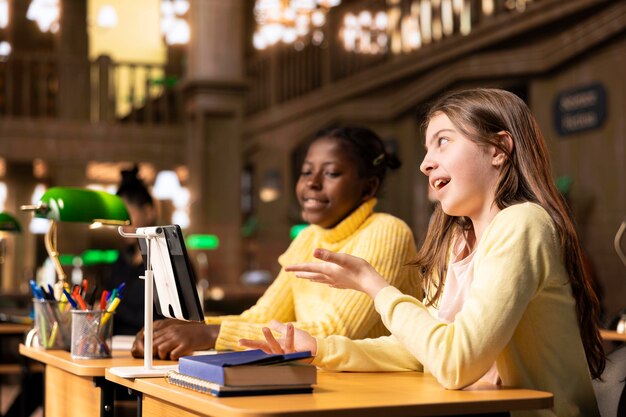 Mädchen, die an einem Kurs in der Bibliothek teilnehmen und sich einem Live-Video-Webinar anschließen