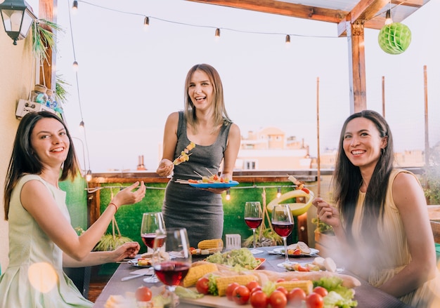 Mädchen, die Aperitifs an der Dachspitzenparty essen