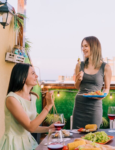 Mädchen, die Aperitifs an der Dachspitzenparty essen