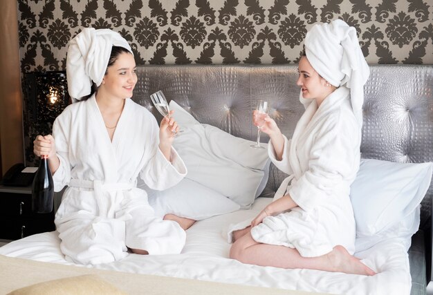 Mädchen, die Badekurorttag mit einem Glas Champagner genießen