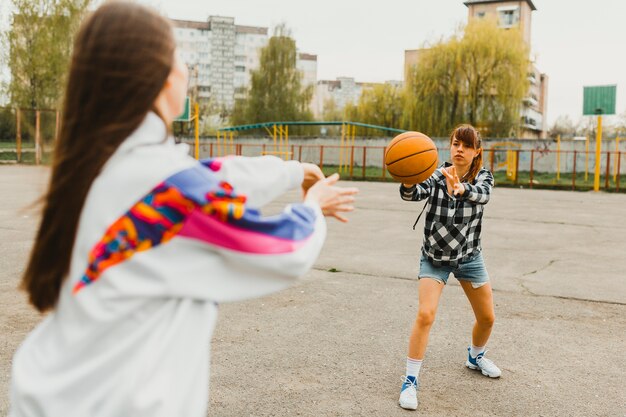 Mädchen, die Basketball übergeben