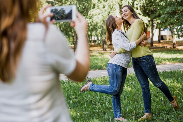 Mädchen, die Fotos beim Küssen auf Backe machen