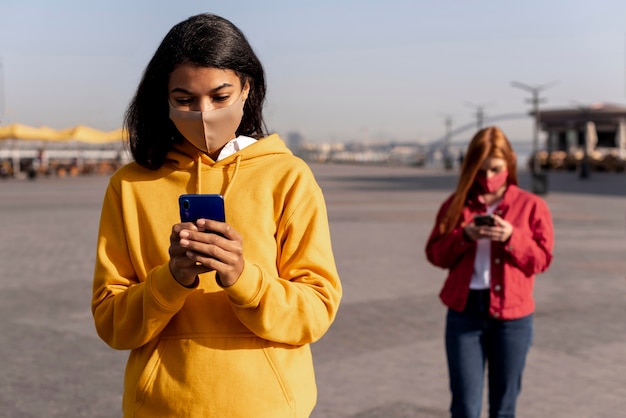 Kostenloses Foto mädchen, die medizinische masken tragen, während soziale distanz