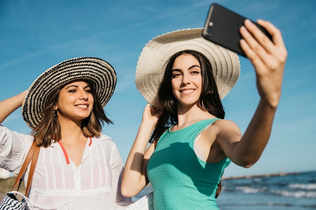 Mädchen, die selfie am Strand nehmen