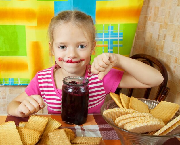 Mädchen essen Marmelade aus Glas