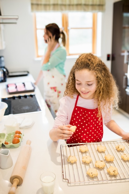 Kostenloses Foto mädchen essen plätzchen in der küche