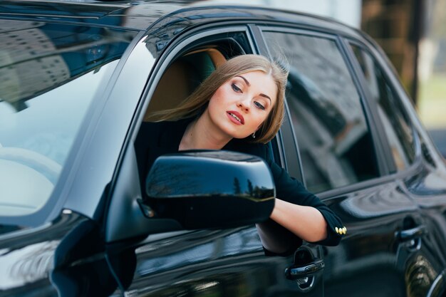 Mädchen fahren ein Auto und schauen vom Fenster auf Stau