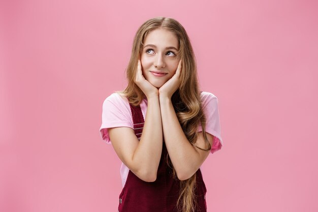 Mädchen fragt sich, ob sie Süßigkeiten im Kühlschrankporträt einer charmanten verträumten jungen Frau im trendigen Outfit hat ...