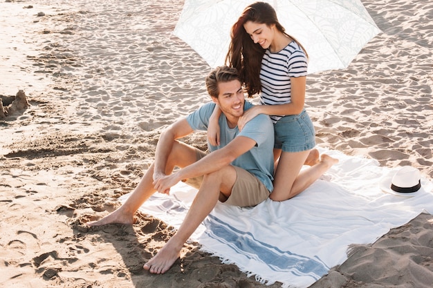 Mädchen geben Massage zum Freund am Strand