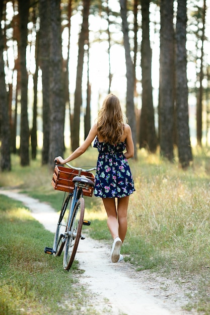 Kostenloses Foto mädchen geht auf einen fahrradweg im wald