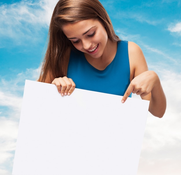 Kostenloses Foto mädchen hält ein plakat mit einem himmel hintergrund