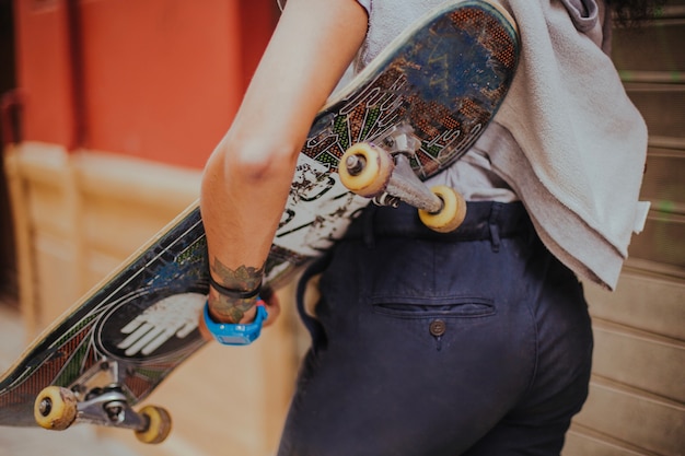 Mädchen hält Skateboard zu Fuß draußen