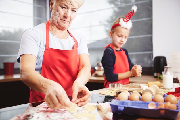 Mädchen helfen ihrer Großmutter, Kekse zu machen