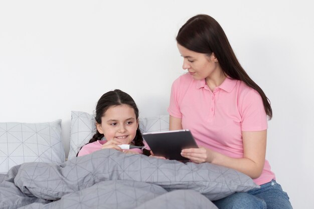 Mädchen im Bett mit Tablette