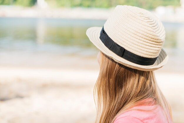 Mädchen im Hut, der Wasser betrachtet