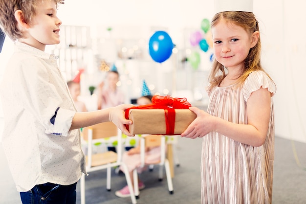 Mädchen im schönen Kleid, das Geschenk nimmt