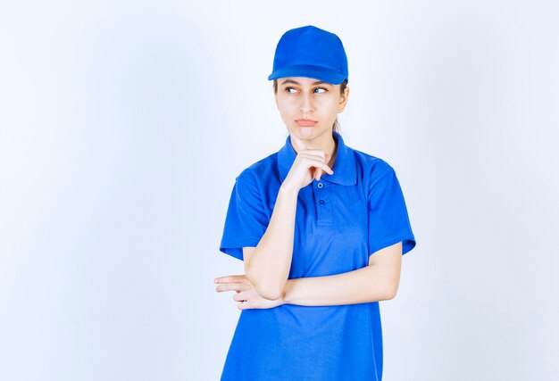 Mädchen in blauer Uniform sieht nachdenklich und planend aus.