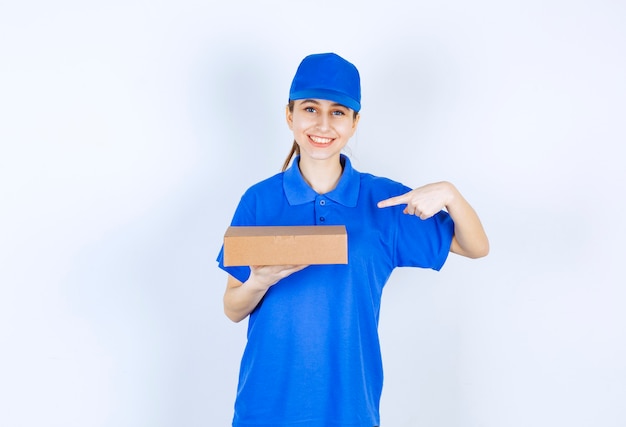 Mädchen in der blauen Uniform, die einen Karton zum Mitnehmen hält.