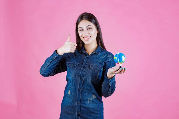 Mädchen in der Jeansjacke, die gutes Handzeichen macht